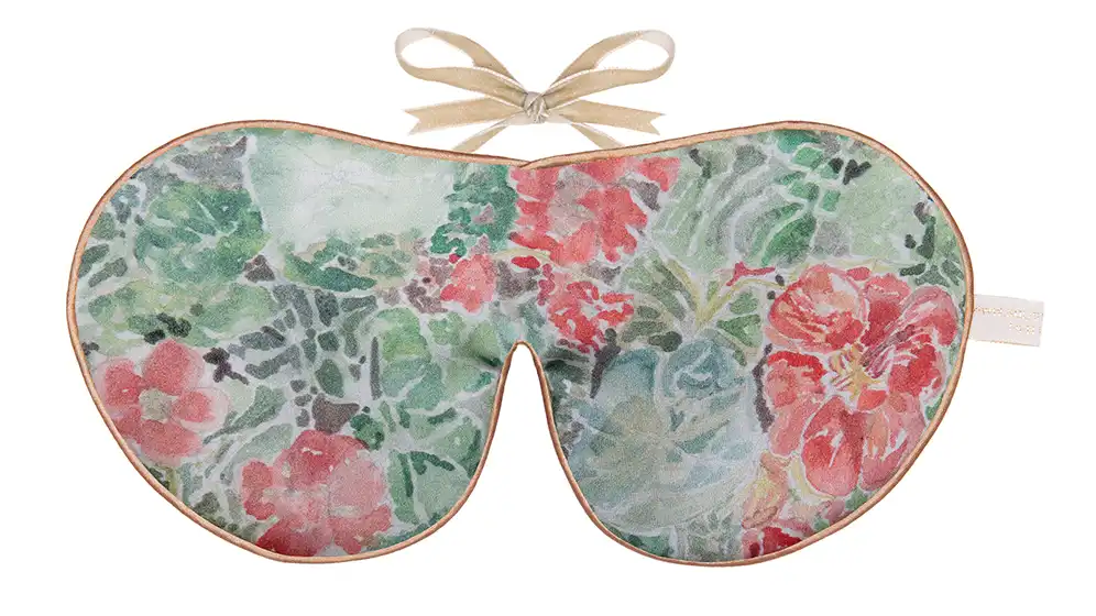 Silk sleep mask with a soft green background featuring coral, red, and pink nasturtium flowers and leaves.