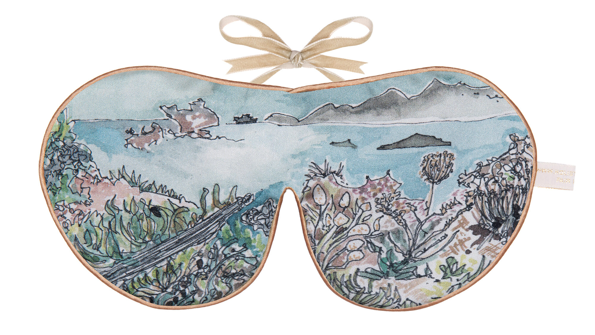 Flat image of the Holistic Silk Excluisve Silk Sleep Mask with a watercolour effect hand drawn coastal scene looking towards some cliffs with natyrstiums in the foreground with Honey colour piping and a Honey colour velvet bow above it on a clear white background.