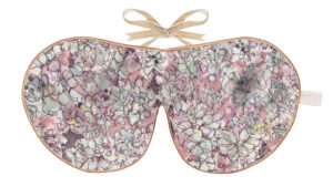 Flat image of the Holistic Silk Excluisve Silk Sleep Mask with a watercolour effect hand drawn succulent plant design with Honey colour piping and a Honey colour velvet bow above it on a clear white background.