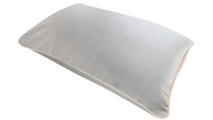 A flat image of the Holistic Silk Pillowcase in Silver colour Mulberry Silk laid diagonally across the shot showing the honey coloured piping.