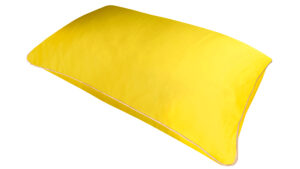 A flat image of the Holistic Silk Pillowcase in Sundrop Yellow Mulberry Silk laid diagonally across the shot showing the honey coloured piping.