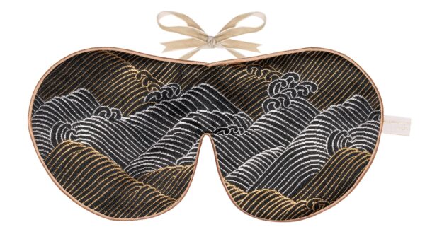 Flat image of the Holistic Silk Limited Edition Brocade Sleep Mask in a Black and gold waves deisn colour with Honey colour piping and a Honey colour velvet bow above it on a clear white background.