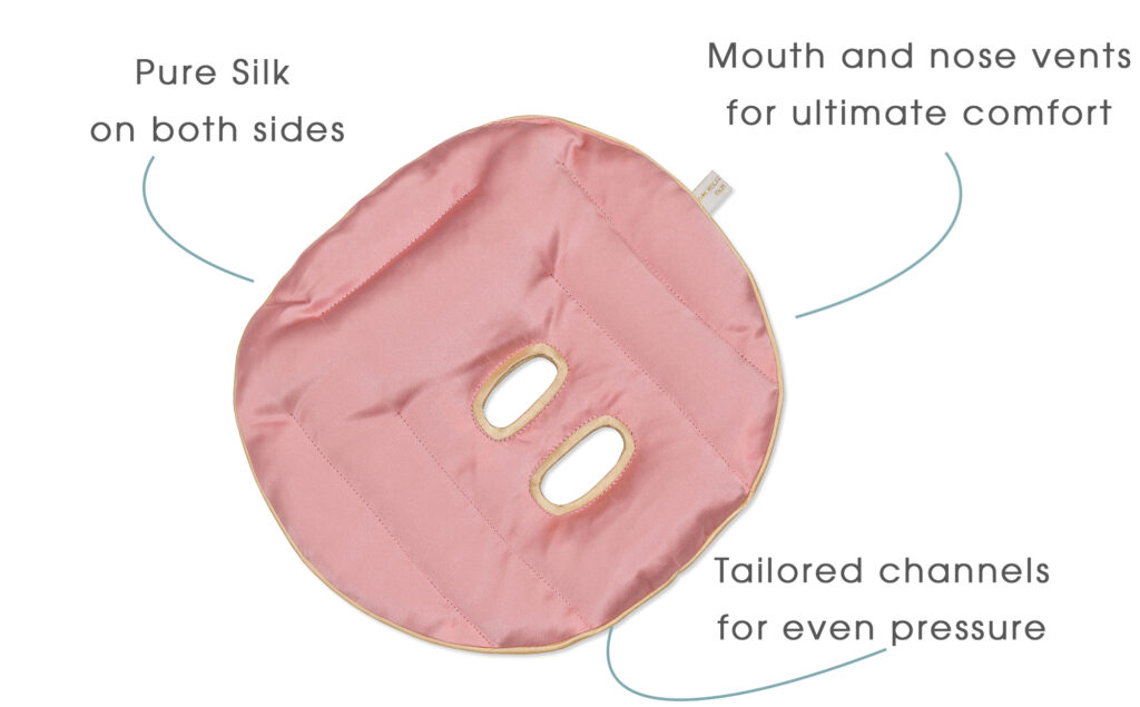 An image of a Rose colour Holistic Silk face Pillow on a white background with grey text and curved lines identifying the key product points