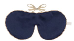 Flat image of the Holistic Silk Classic Silk Sleep Mask in a Navy colour with Honey colour piping and a Honey colour velvet bow above it on a clear white background.