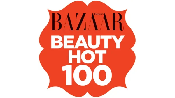 Harper’s Bazaar Beauty Hot 100 badge in bold coral with white text and scalloped edges