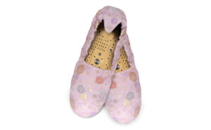 A flat image of a pair of Holistic Silk Brocade Massaging Slippers in a Rose Japanese Rose floral design. The slippers are crossed at the heel shwoing the magentic insoles inside.