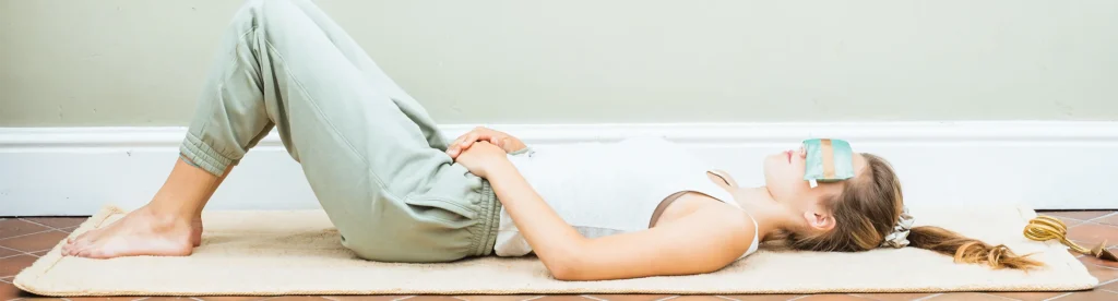 Girl lying on yoga mat with a Holistic Silkeye pillow