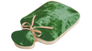 An emerald green silk velvet hot water bottle cover with gold trim and beige ribbon ties.