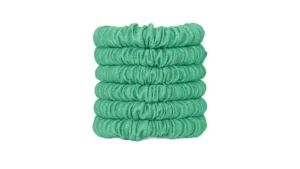 A stack of skinny silk scrunchies in a Jade Green shade, neatly arranged to show their smooth gathered texture