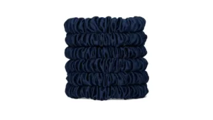 A stack of skinny silk scrunchies in a Navy Blue shade, neatly arranged to show their smooth gathered texture