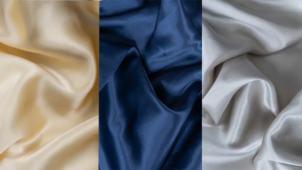 Three silk fabrics in cream, navy, and silver shades, each shown with soft folds and a glossy texture