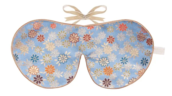 Lavender blue silk sleep mask with scattered floral pattern and honey coloured trim with ribbon fastening