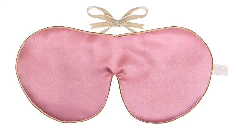 Rose colour silk sleep mask with honey‑coloured piping and silk ribbon tie, shown flat on a white background.