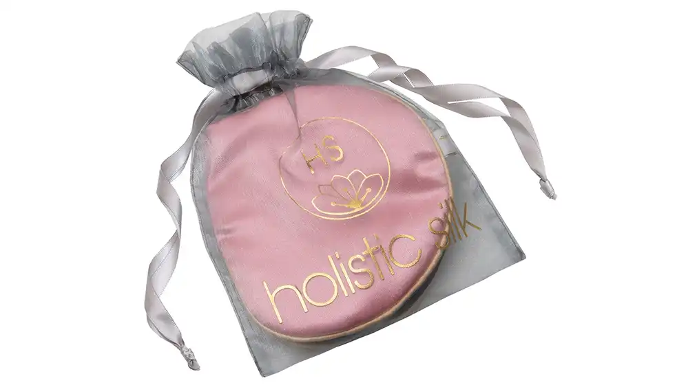 Pure silk rose pink eye mask with honey‑coloured trim, embroidered Holistic Silk logo, presented inside a sheer silver organza drawstring bag.